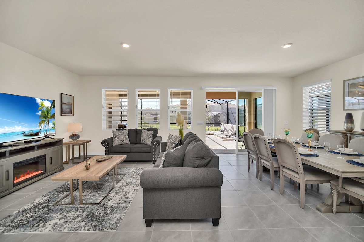 Spacious living and dining area with cozy seating, fireplace, and seamless patio access, ideal for entertaining and relaxation.