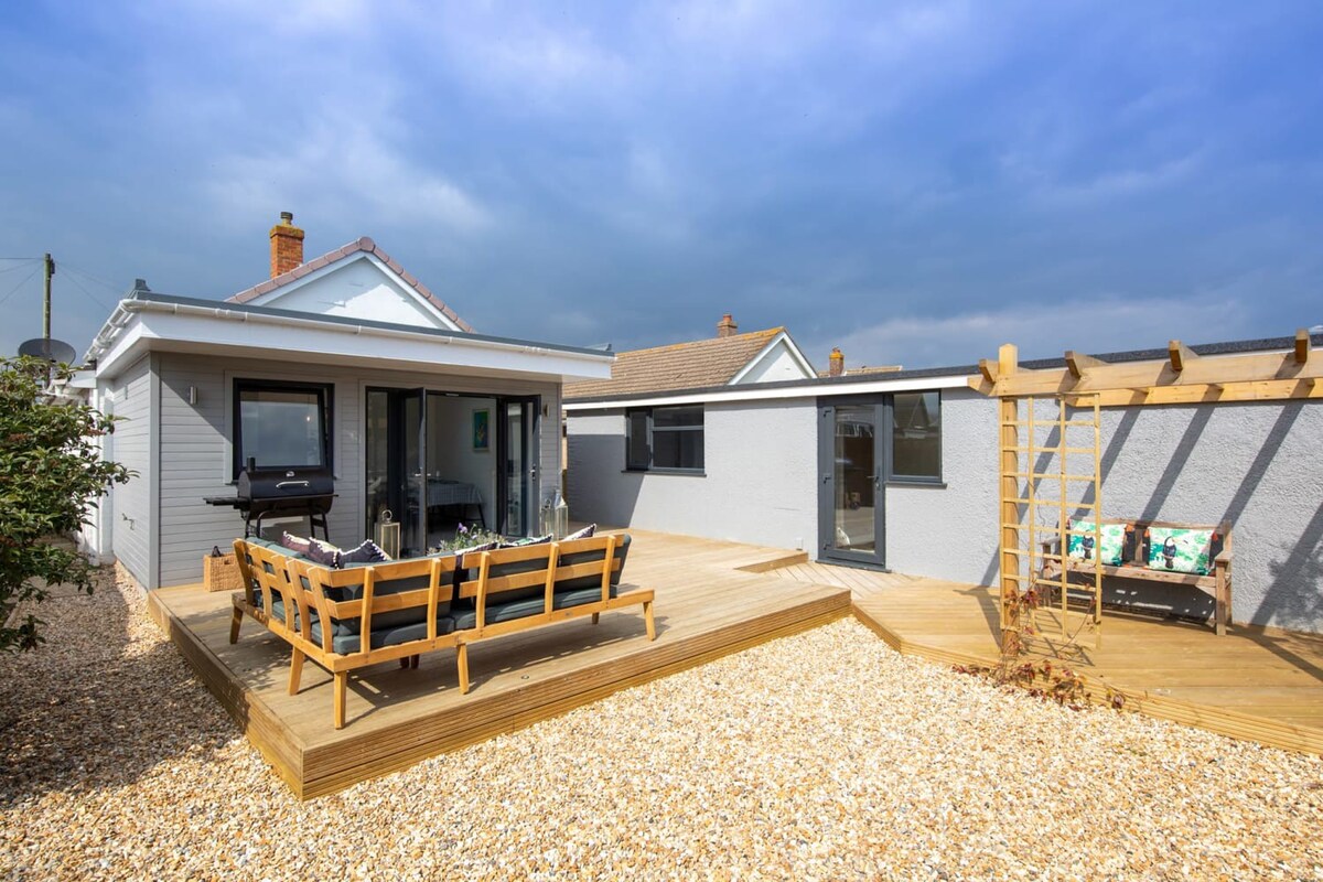 Wooden deck offers a comfortable lounge and a modern BBQ grill