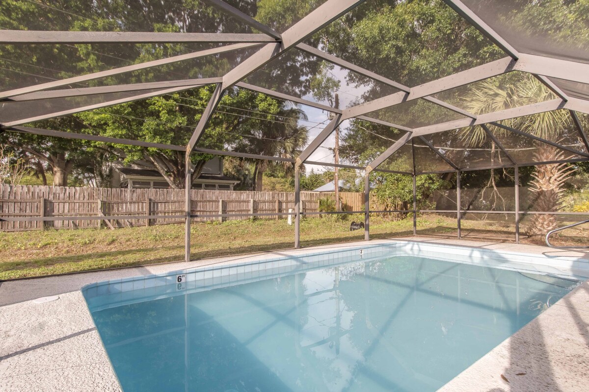 Private backyard pool is located within an enclosed screen area.