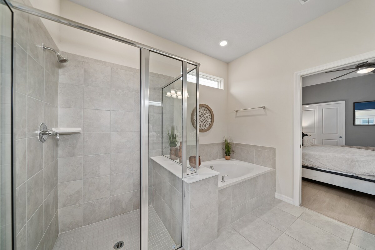 Another full bathroom attached to a bedroom features bright, modern design.
