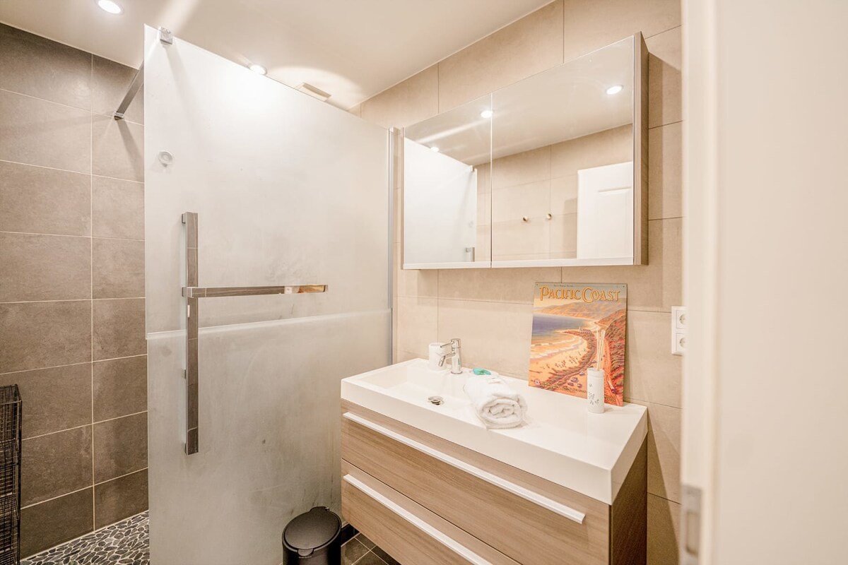 The bathroom is modern with rich finishes & fixtures