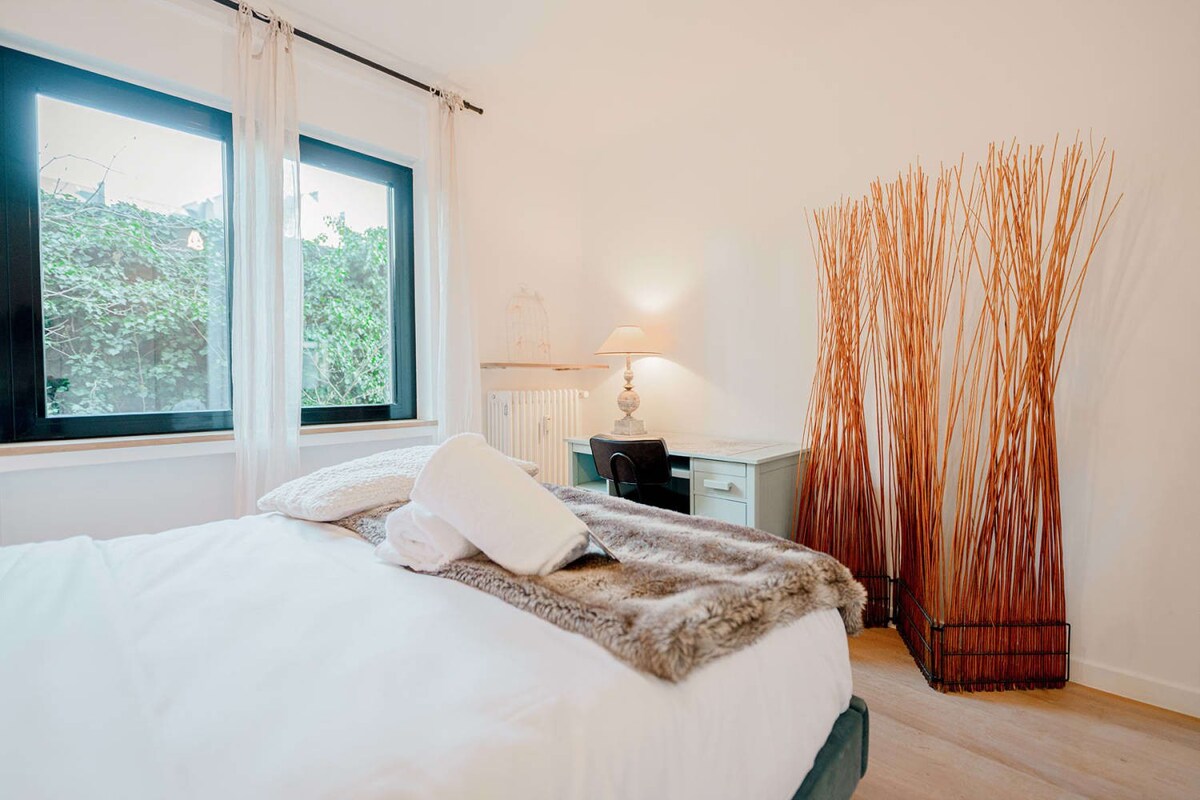 Bedroom 1 with plush queen bed, work desk & great natural lighting