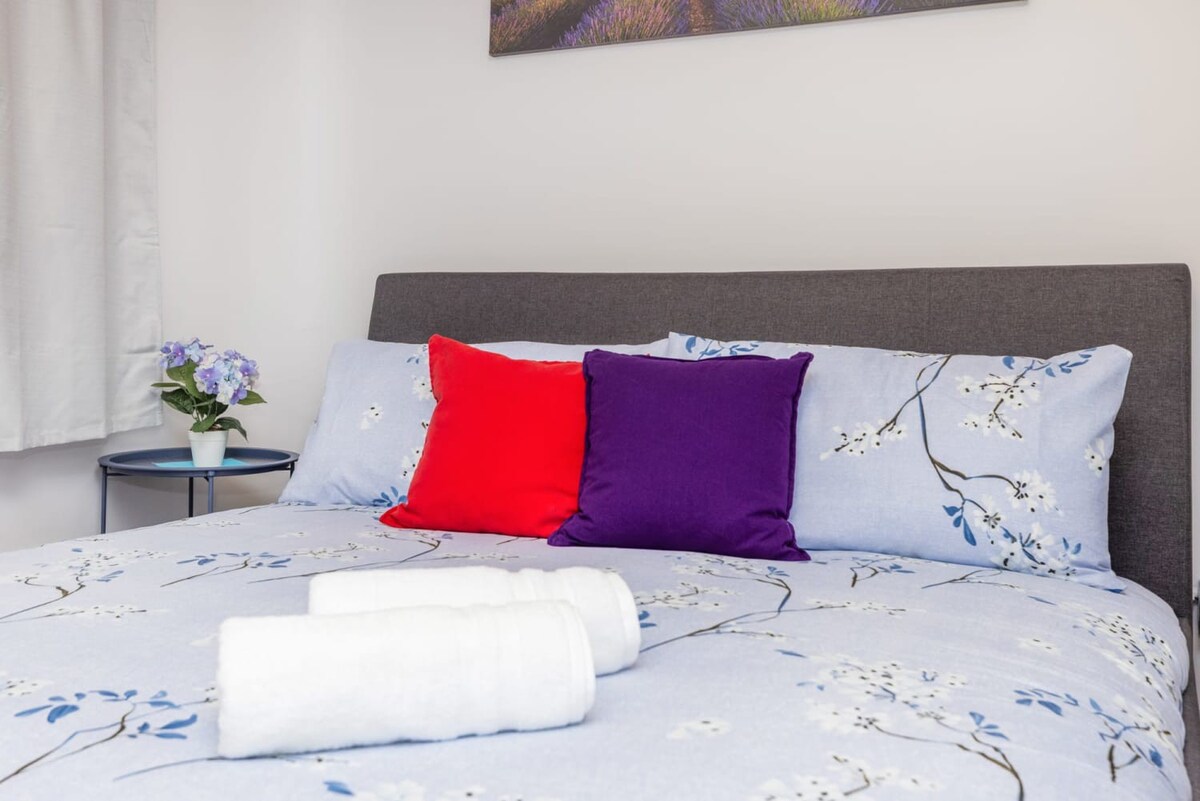Rest Easy On A Stylish Bed With Elegant Floral Bedding And Vibrant Pillows