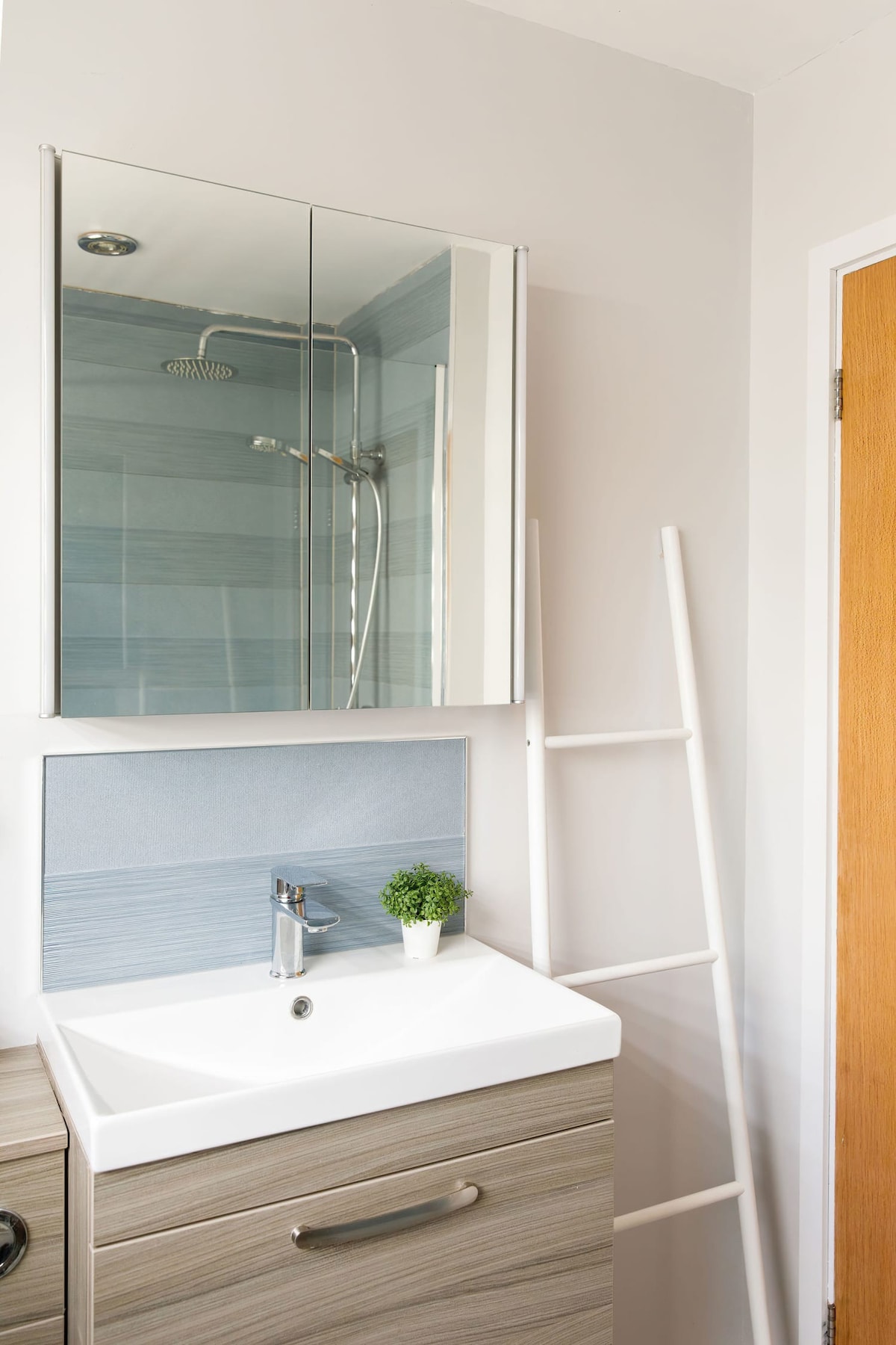 The bathroom sink with overhead mirrored cabinet.