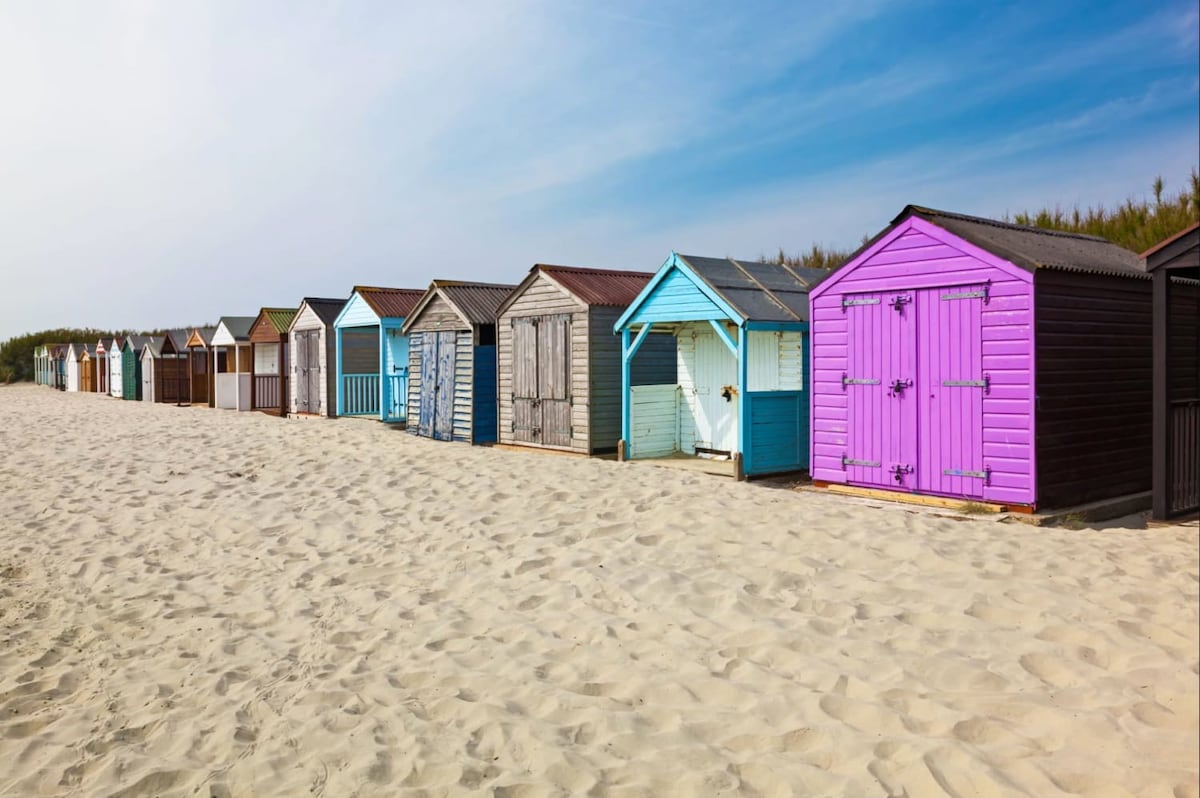 Colourful huts line West Wittering Beach.