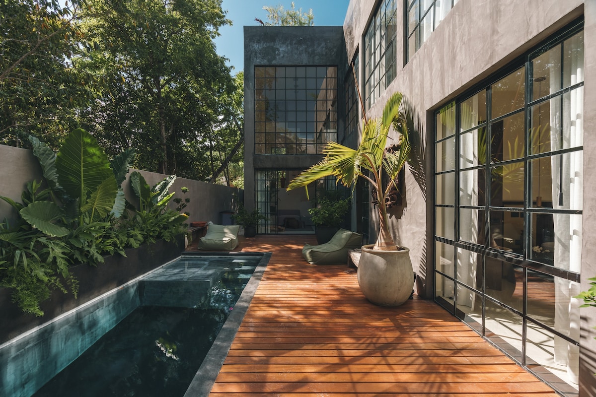 Elegant backyard featuring a pool and a deck with sun loungers.