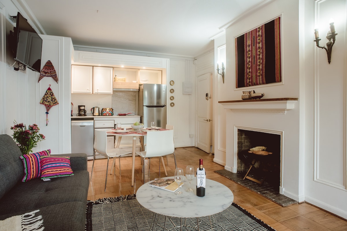 Charming living space with a cozy fireplace, vibrant decor, and a modern kitchen—perfect for a relaxing getaway.