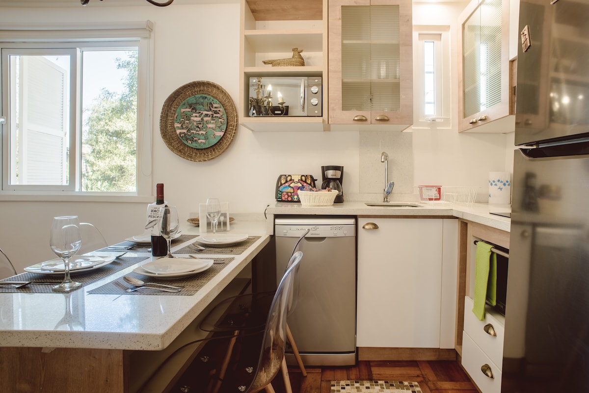 Cozy kitchen with modern amenities and a charming dining area, perfect for intimate meals.