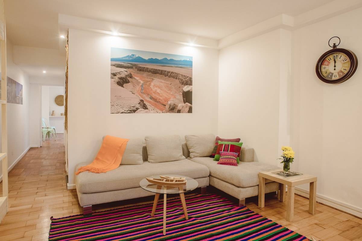 Cozy living room with vibrant decor and a comfy sectional sofa, perfect for relaxing after a day of exploring.