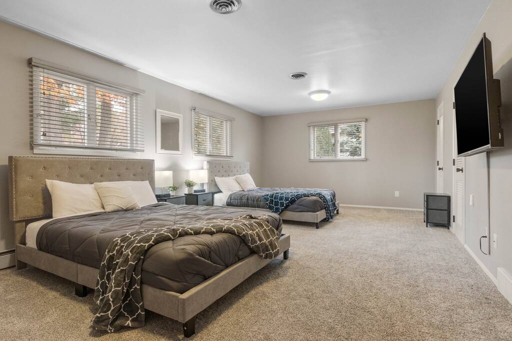 This large bedroom has two queen bed's and a TV.