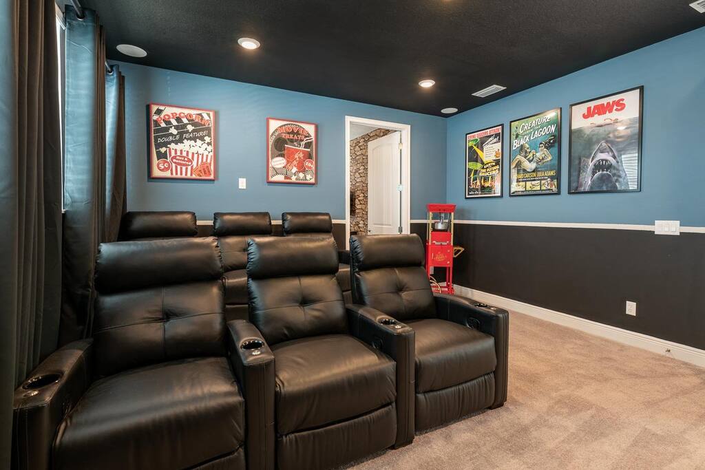 Experience movie nights like never before in this cozy home theater with plush recliners and classic movie posters.