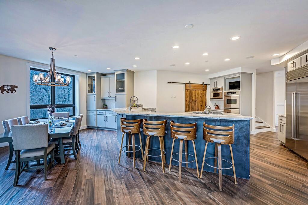 Dining area w/ wood table and open flow to the kitchen and living room.