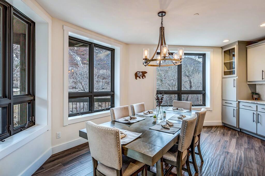 Open dining space w/ modern table, natural light, and seamless flow to the kitchen.