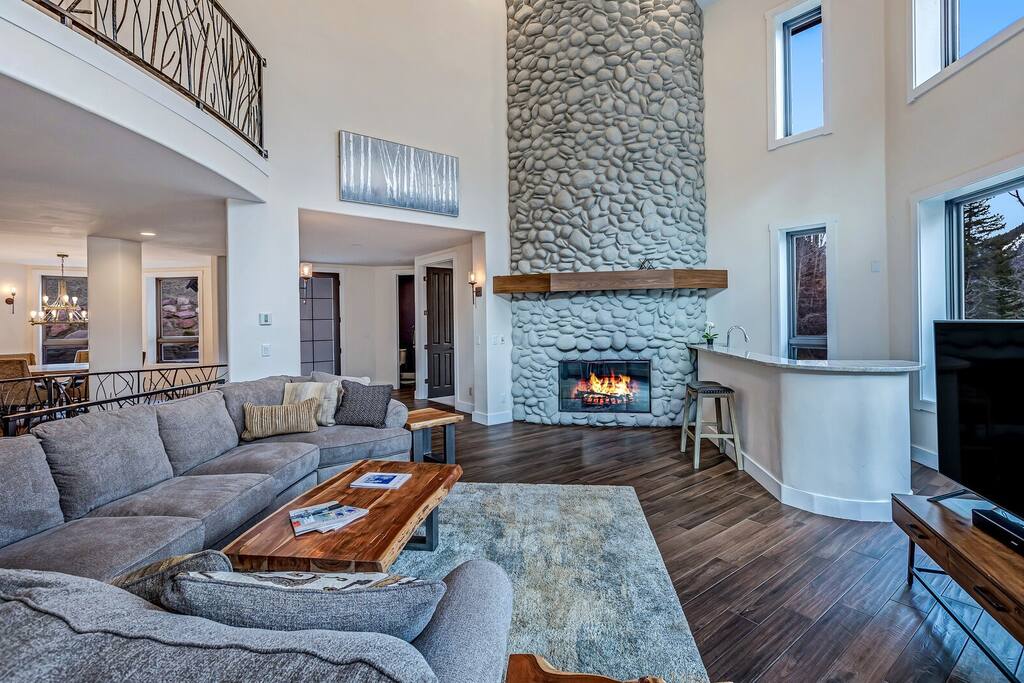 Inviting living room w/ plush seating, stone fireplace, and soaring ceilings for relaxed group gatherings.