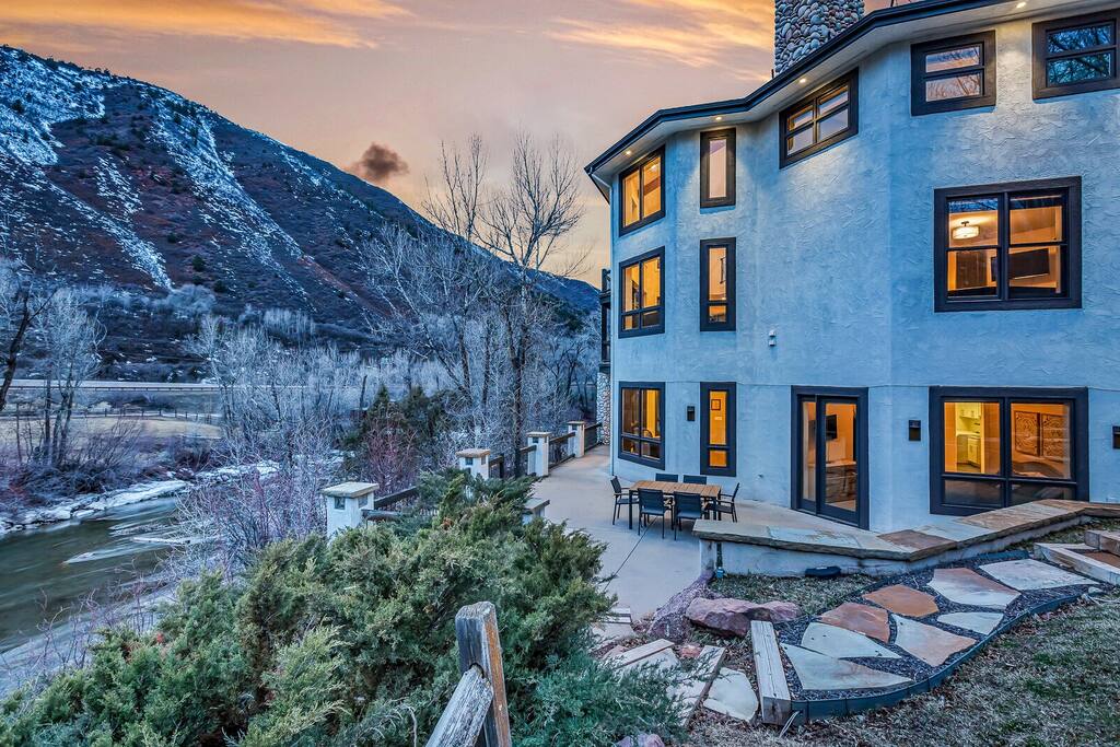 Twilight exterior glowing warmly against the mountain backdrop.
