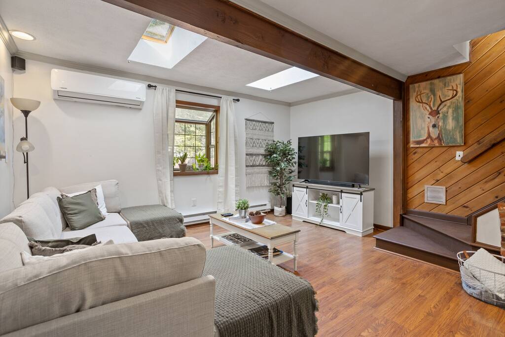 Living Room with Wood Beams and TV
An airy, open living space with exposed beams, a large sectional, and a wall-mounted TV ready for movie nights or morning news.