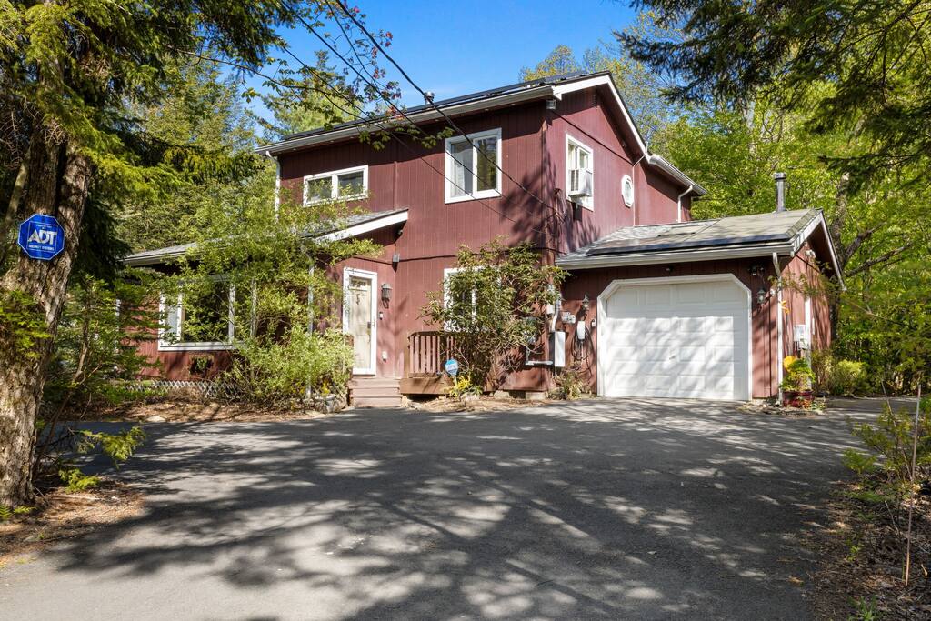 Exterior Front View
Tucked among the trees, this charming red cabin-style home welcomes you with character, privacy, and a paved drive leading right to the door.