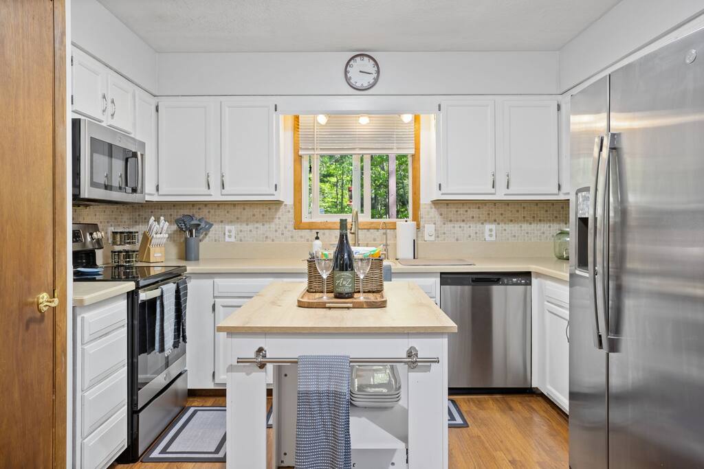 Kitchen Overview with Island
A welcoming kitchen setup featuring white cabinetry, stainless appliances, and a central island that’s perfect for meal prep or casual bites.