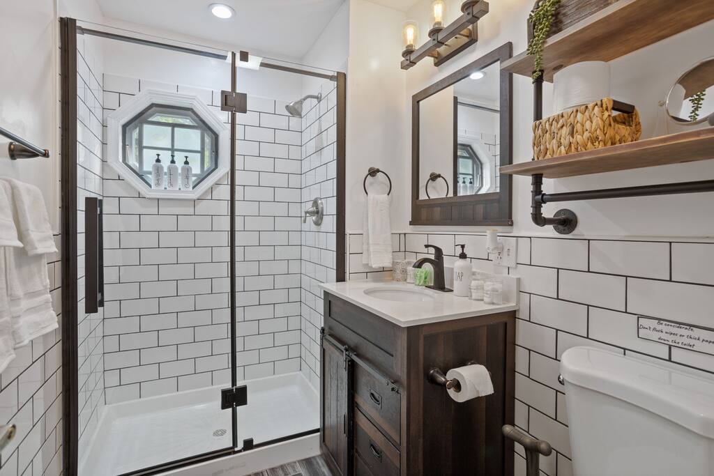 Bathroom with Walk-In Shower
This bathroom blends farmhouse charm with modern details, subway tile, matte black fixtures, and a sliding glass door for a crisp, clean look.