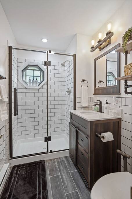 Walk-In Shower with Octagon Window
A fresh, modern bathroom with subway tile, matte black finishes, and a unique octagonal window that adds charm and natural light.
