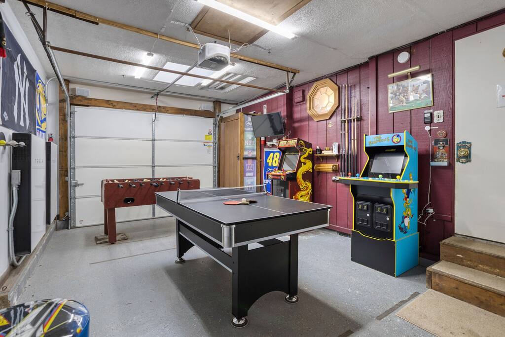 Garage Game Room
This converted garage brings the fun with a ping pong table, arcade games, and playful pops of color in a spacious setup perfect for all ages.