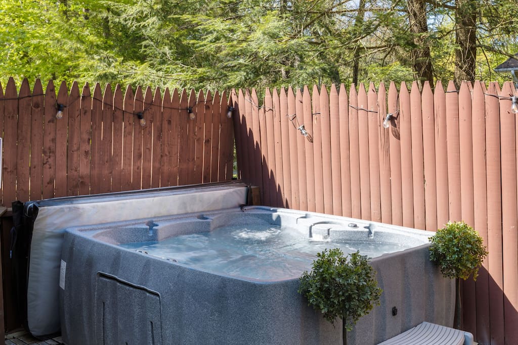 Tucked in behind a rustic wood fence and framed by evergreens, this bubbling hot tub offers a quiet, secluded spot to relax. Whether you're soaking under the string lights or catching some afternoon sun, it's the perfect way to unwind in nature.