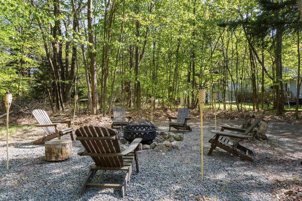 Fire Pit Circle in the Woods
End the evening fireside under the stars. Adirondack chairs surround a stone fire pit nestled in the trees, perfect for s’mores and stories.